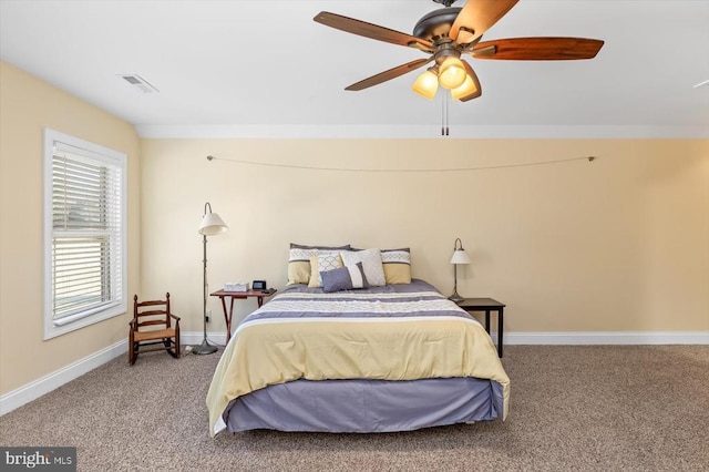 carpeted bedroom featuring baseboards, visible vents, and a ceiling fan