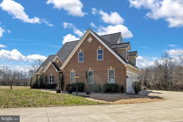 view of front of property featuring driveway, an attached garage, and brick siding