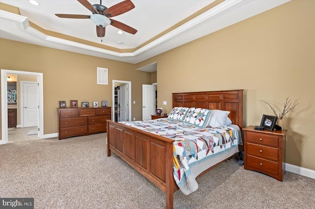 bedroom with baseboards, a tray ceiling, visible vents, and light colored carpet