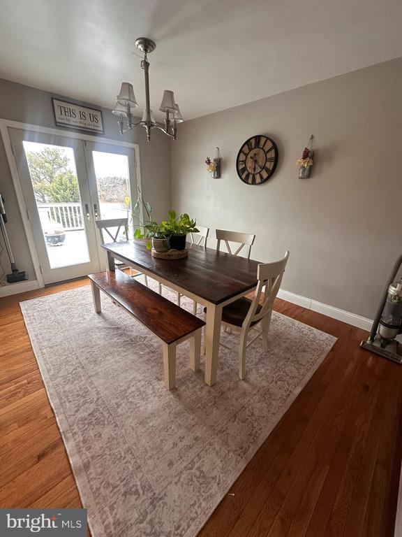 dining room featuring french doors, dark hardwood / wood-style flooring, and a chandelier