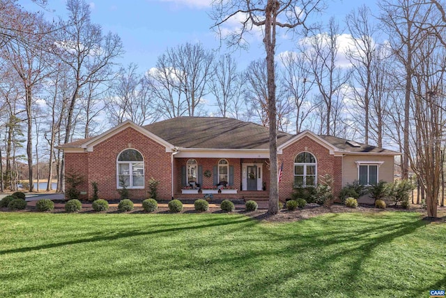 ranch-style home featuring brick siding, a porch, and a front yard