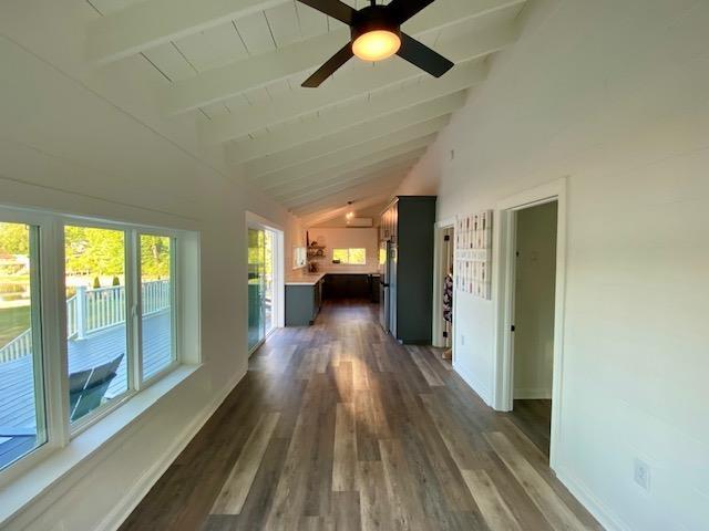 hall featuring dark hardwood / wood-style flooring and lofted ceiling with beams