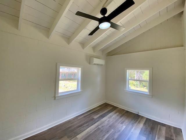 empty room with vaulted ceiling with beams, an AC wall unit, ceiling fan, dark hardwood / wood-style flooring, and wood ceiling