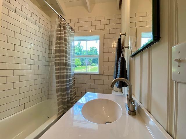 bathroom with sink and shower / bathtub combination with curtain