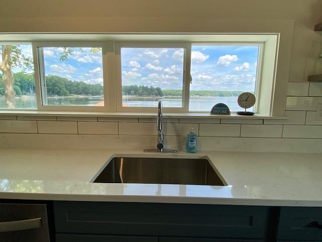 kitchen featuring a water view, sink, and decorative backsplash