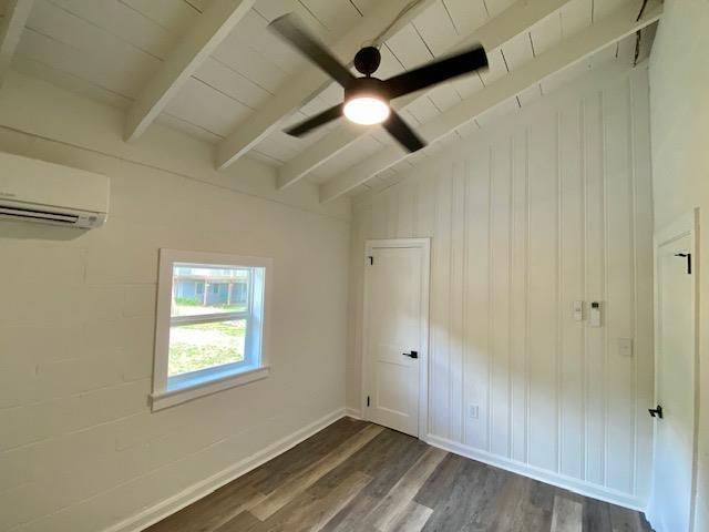 interior space with dark hardwood / wood-style flooring, ceiling fan, wood ceiling, and an AC wall unit