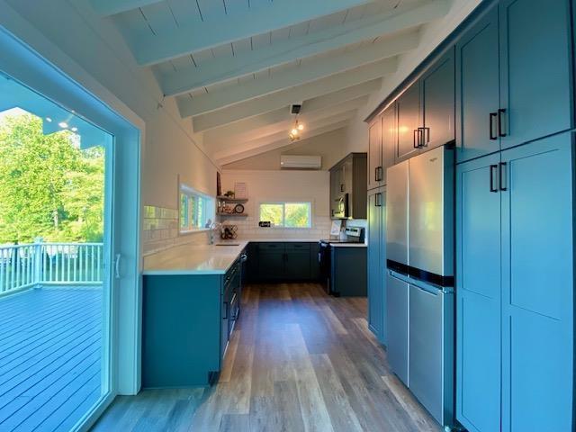 kitchen featuring electric range, vaulted ceiling with beams, decorative backsplash, and a wall mounted air conditioner