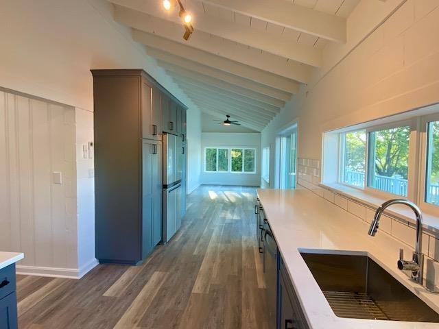 interior space featuring high vaulted ceiling, sink, dark hardwood / wood-style floors, and beam ceiling