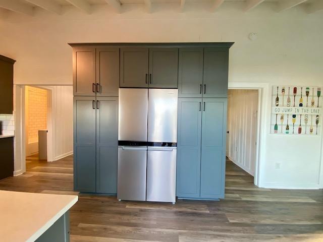 kitchen featuring stainless steel refrigerator, dark wood-type flooring, and beam ceiling