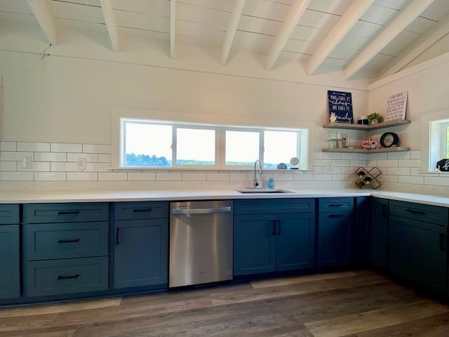 kitchen with dishwasher, backsplash, lofted ceiling with beams, and sink