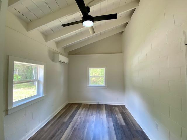 spare room with wood ceiling, a wall unit AC, ceiling fan, lofted ceiling with beams, and dark wood-type flooring