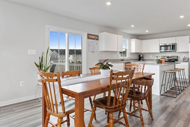 dining area with recessed lighting, light wood-style flooring, and baseboards