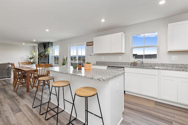 kitchen featuring a center island, a sink, a breakfast bar, and recessed lighting