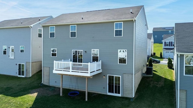 rear view of property featuring a lawn, a deck, and central AC unit
