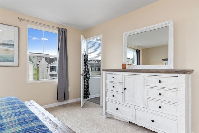 bedroom with light carpet and baseboards