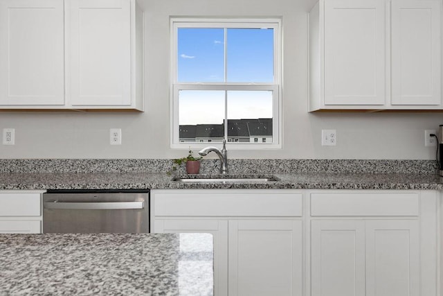 kitchen with light stone counters, dishwasher, white cabinetry, and a sink