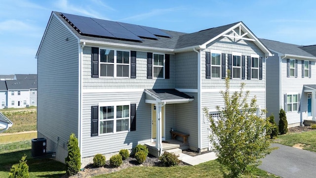 view of front of property featuring roof mounted solar panels and central AC unit