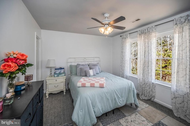 bedroom with visible vents, ceiling fan, baseboards, and multiple windows