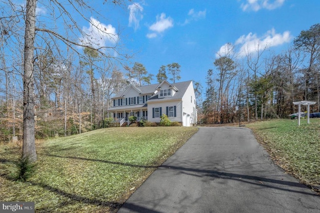 view of front of property featuring aphalt driveway, an attached garage, and a front lawn