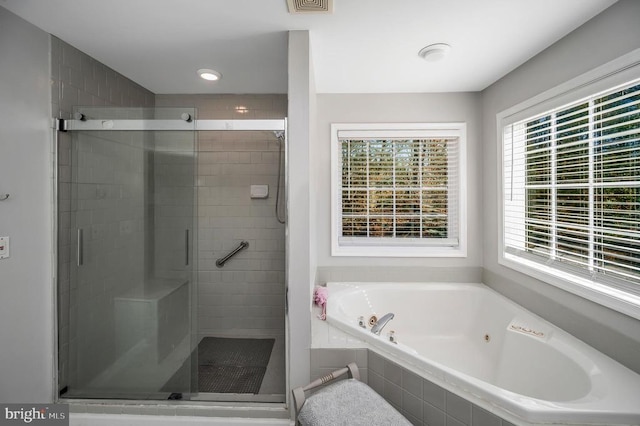 bathroom featuring a jetted tub, visible vents, and a stall shower