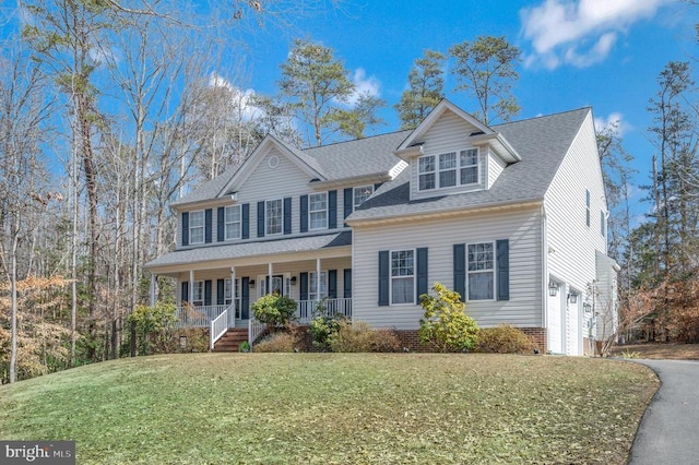 view of front of property featuring covered porch, a garage, driveway, roof with shingles, and a front yard