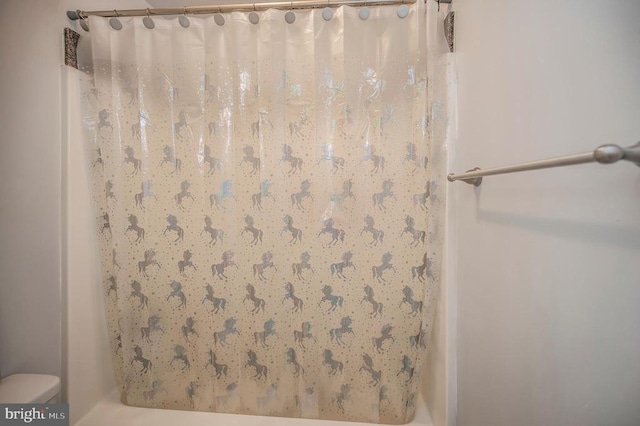 bathroom with curtained shower and toilet