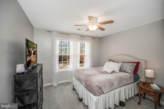 bedroom featuring a ceiling fan, visible vents, light carpet, and baseboards