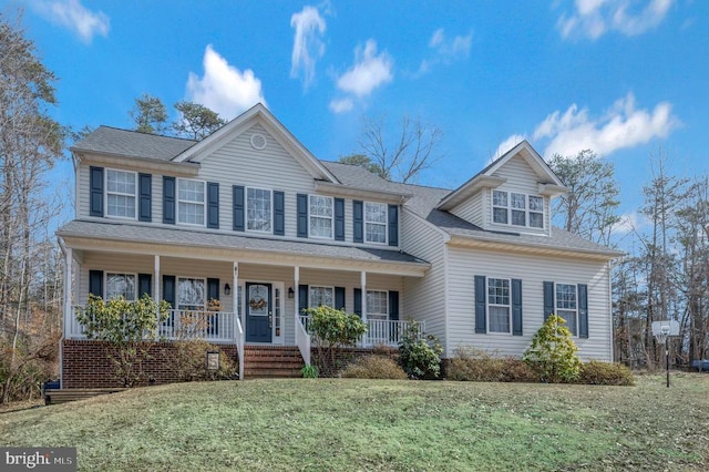 view of front of property with a shingled roof, covered porch, and a front lawn