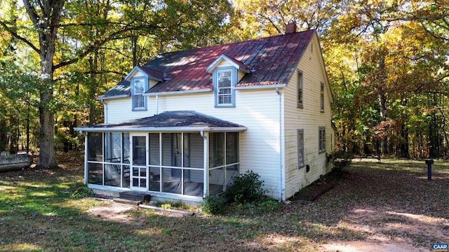 rear view of house featuring a sunroom