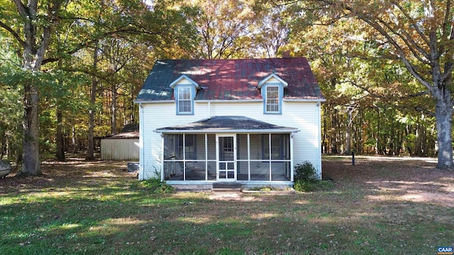 back of house with a sunroom and a lawn