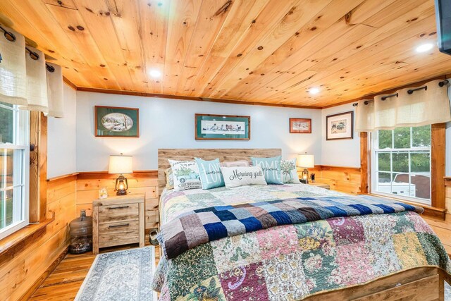 bedroom with a wainscoted wall, wood walls, wooden ceiling, and wood finished floors