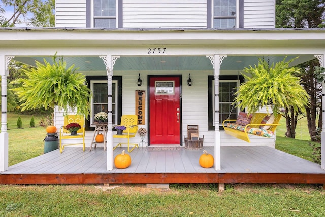 property entrance featuring covered porch and a yard