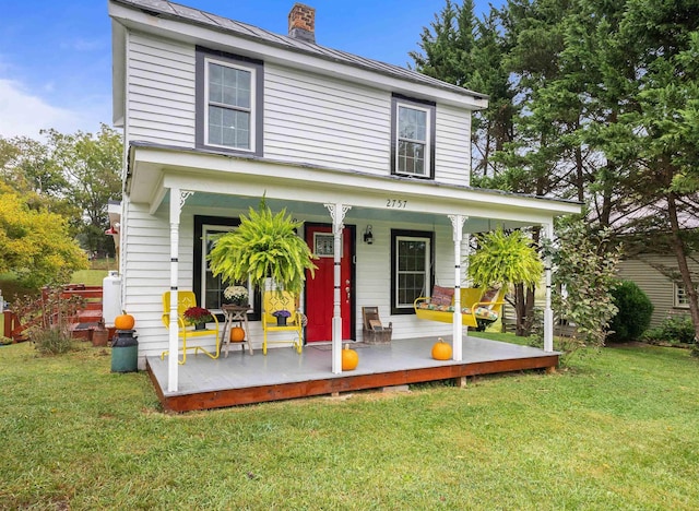 view of front of house with a chimney, a front lawn, and a porch