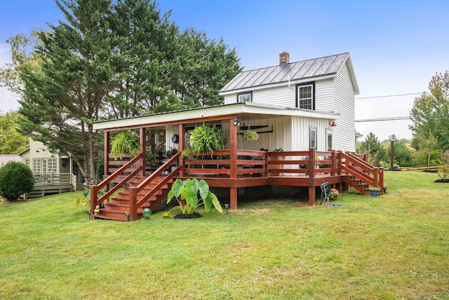 view of front of house with a chimney, stairway, metal roof, a deck, and a front lawn