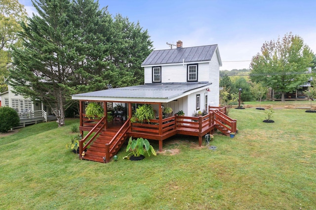 view of front of property featuring metal roof, a front lawn, a chimney, and a wooden deck