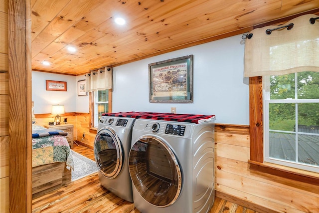 laundry area featuring washing machine and dryer, a wainscoted wall, laundry area, wood walls, and wood ceiling