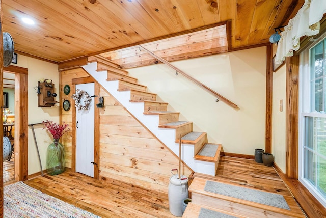 stairway with wooden ceiling and wood finished floors