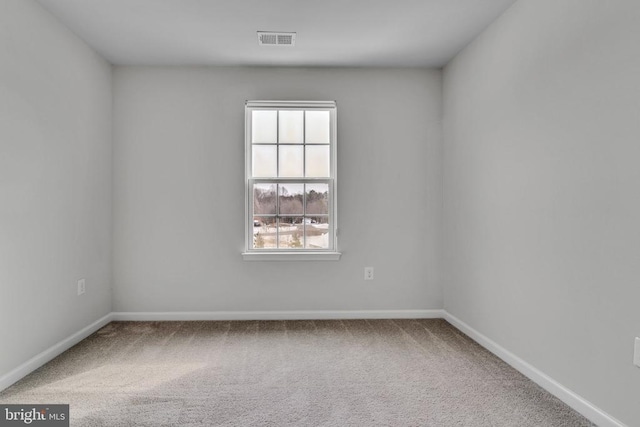 carpeted empty room with visible vents and baseboards