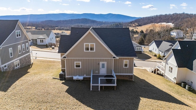 rear view of house featuring a mountain view and central AC unit