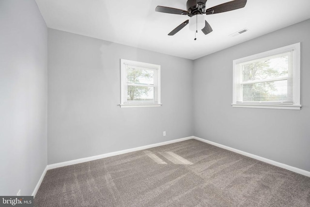 carpeted empty room with a ceiling fan, visible vents, and baseboards