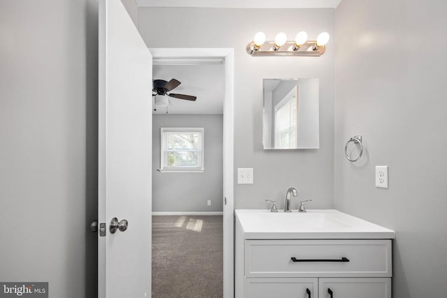 bathroom with baseboards, vanity, and a ceiling fan