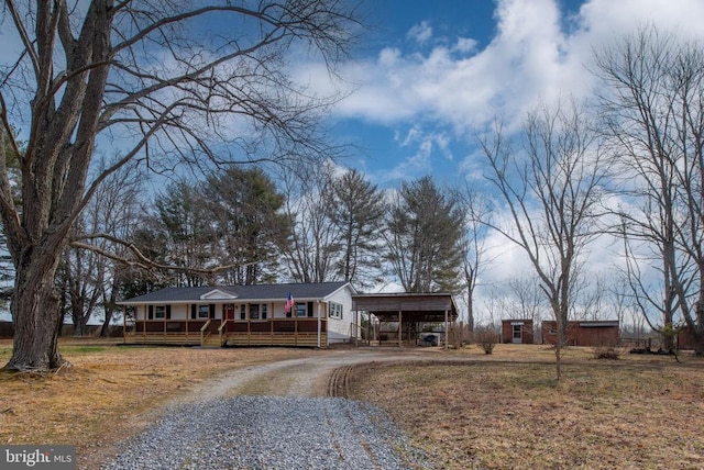 single story home with a carport, driveway, and a wooden deck