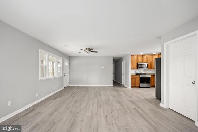 unfurnished living room featuring ceiling fan, light wood finished floors, and baseboards