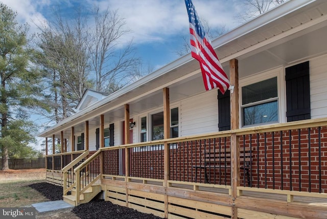 view of property exterior with a porch and brick siding