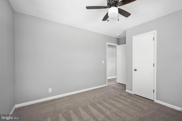 unfurnished bedroom with ceiling fan, carpet, and baseboards