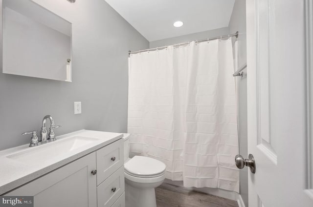 bathroom with toilet, wood finished floors, and vanity