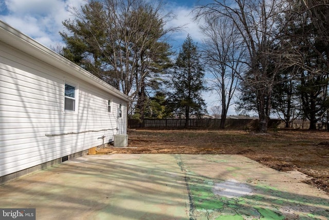 view of yard with central AC unit, fence, and a patio