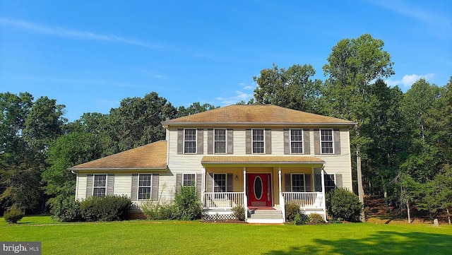 colonial house featuring a front lawn and covered porch