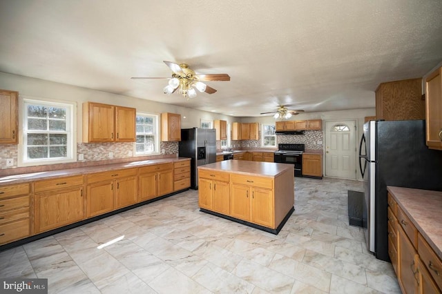 kitchen featuring stainless steel refrigerator, backsplash, stainless steel refrigerator with ice dispenser, a kitchen island, and black range with electric cooktop