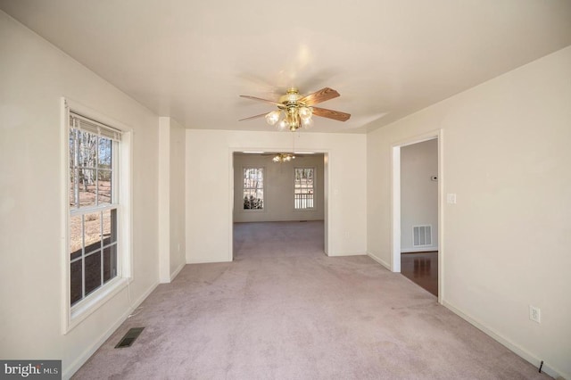 carpeted spare room featuring ceiling fan